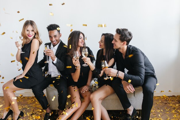 Young friends having fun and drinking champagne at the party