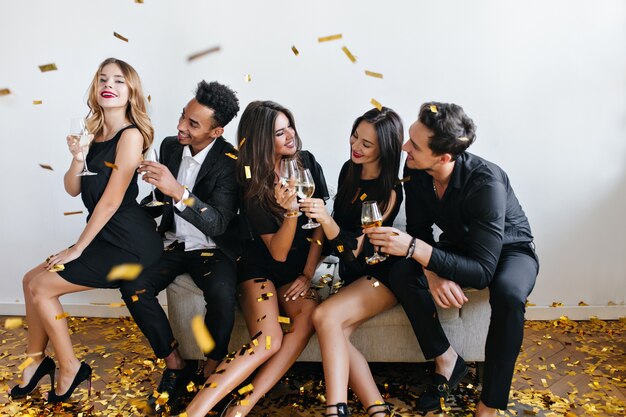 Young friends having fun and drinking champagne at the party