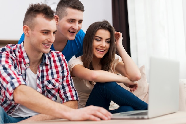 Young friends looking on laptop at home