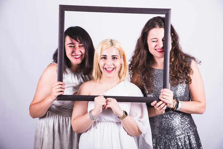 Free Photo young friends posing with a frame