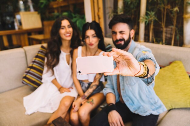 Young friends taking selfie in lounge