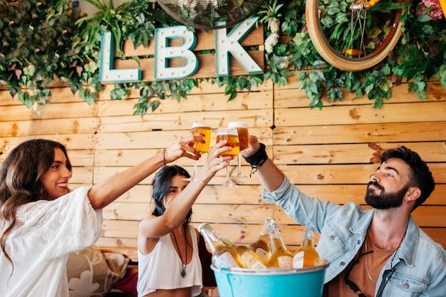 Free photo young friends toasting with beer