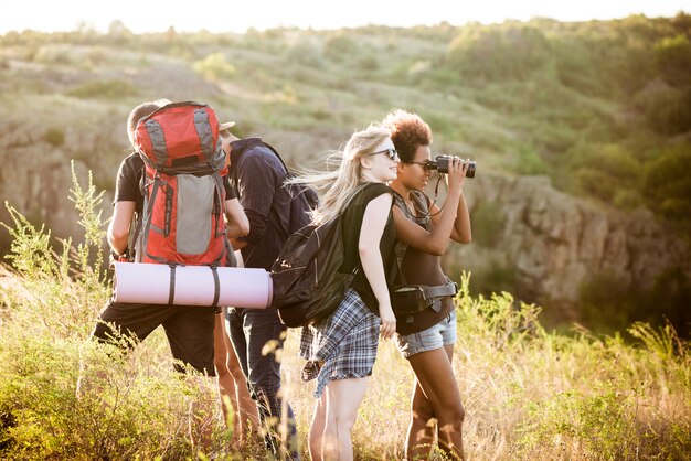 Young friends with backpacks enjoying view, traveling in canyon