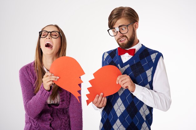 Young funny looking geek couple breaking up isolated
