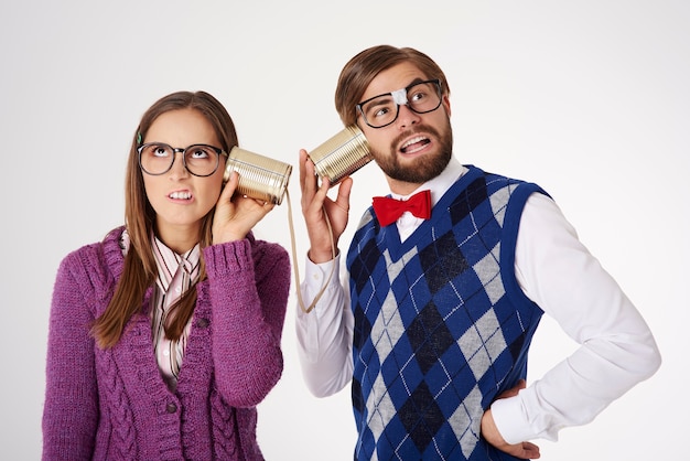 Giovani coppie di sguardo divertente del geek che hanno divertimento isolato