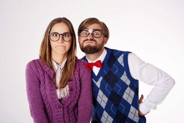 Young funny looking geek couple having fun isolated