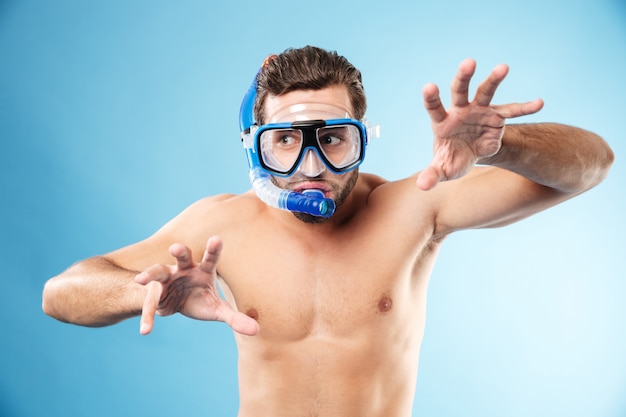 Foto gratuita giovane uomo divertente che gioca con le mani e che indossa la maschera d'acqua