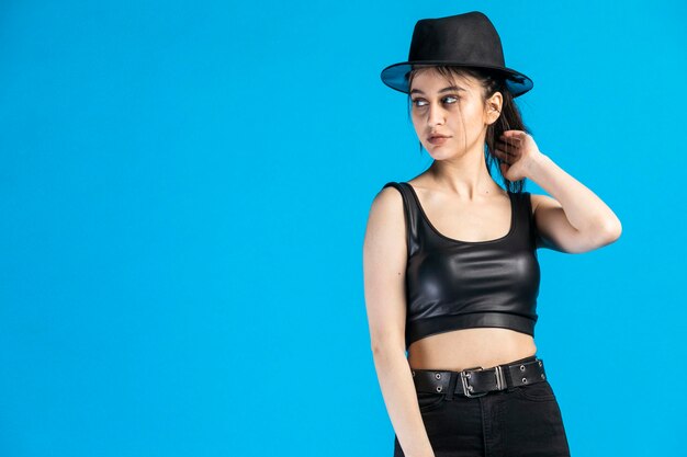 Young gangster wearing black and stand on blue background