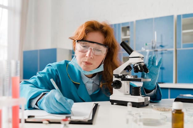 Young ginger woman chemist writing