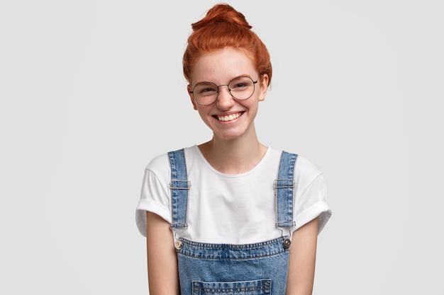 Free photo young ginger woman wearing denim overalls