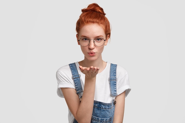 Giovane donna allo zenzero che indossa una tuta in denim