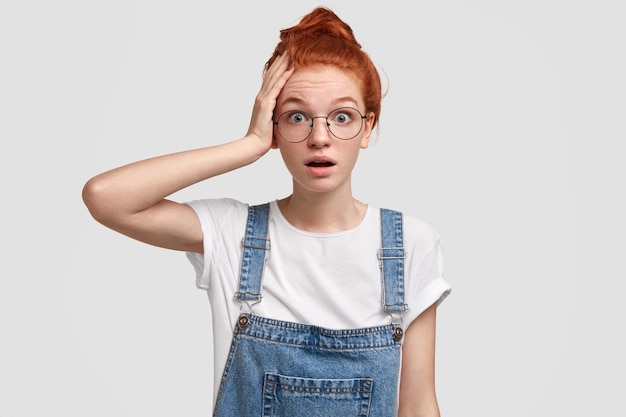Бесплатное фото Молодая рыжая женщина в джинсовом комбинезоне