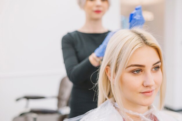 Young gir sitting in chair of hairdresser