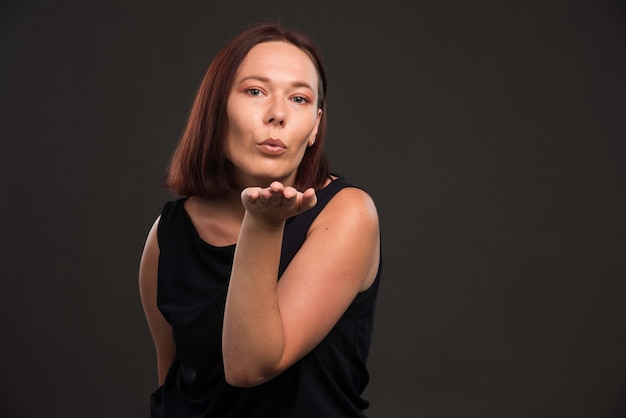 Young girl in black shirt blowing kiss.