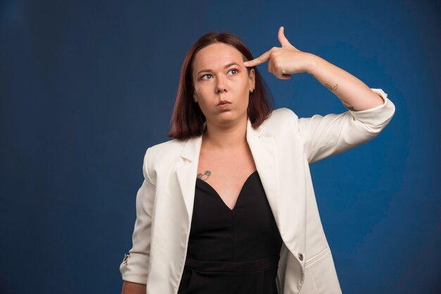 Young girl in black shirt putting gun to her head. 