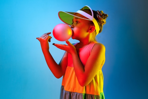 Foto gratuita ragazza giovane soffiando gomma da masticare
