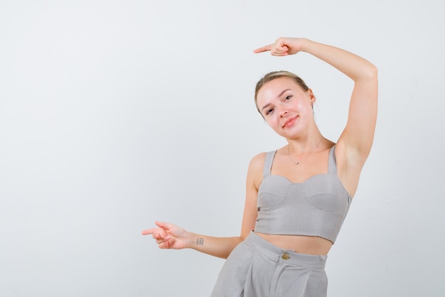 Young girl bowing her head and showing the left with fingers on white background