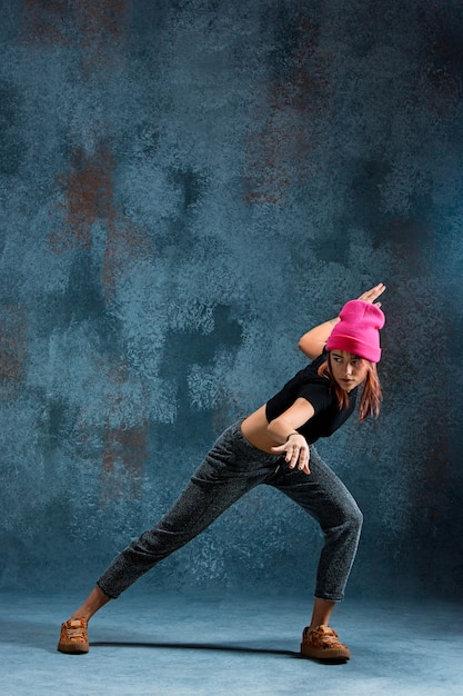 Free photo young girl break dancing on blue.