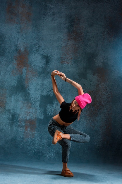 Young girl break dancing on blue.