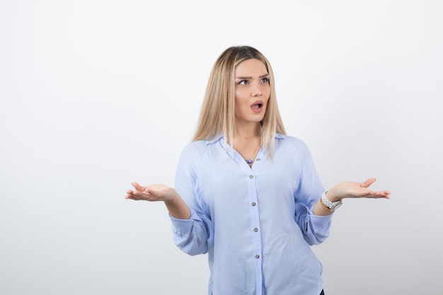 Young girl in casual outfit looking at someone on white. 