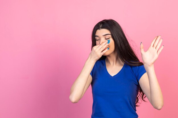 Young girl closed her nose with her hands