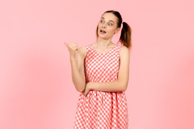 young girl in cute bright dress on pink