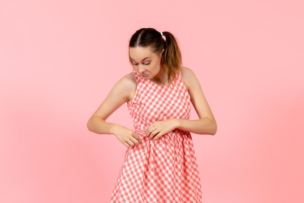 Foto gratuita giovane ragazza in abito luminoso carino con espressione confusa sul rosa