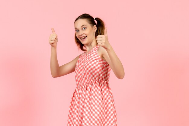 young girl in cute bright dress with excited expression on pink