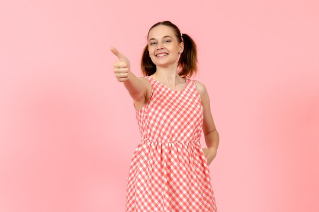 young girl in cute bright dress with happy expression on pink