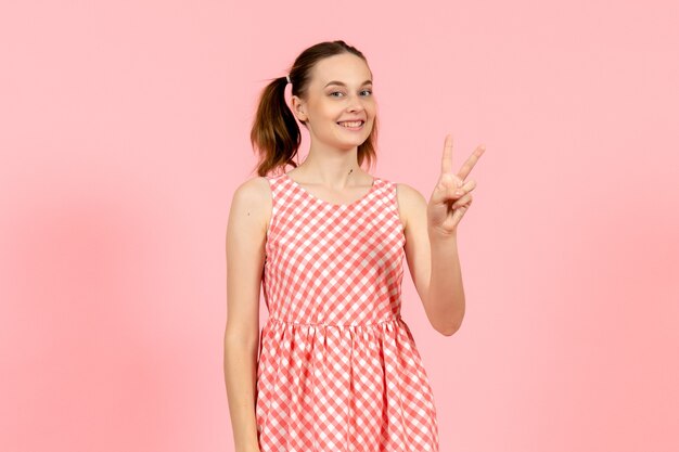 young girl in cute bright dress with happy expression on pink