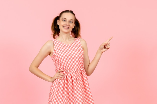 Free photo young girl in cute bright dress with smiling expression on pink