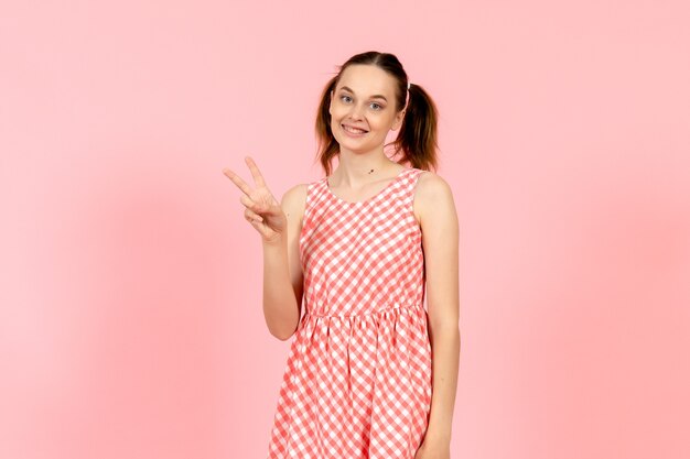young girl in cute bright dress with smiling expression on pink