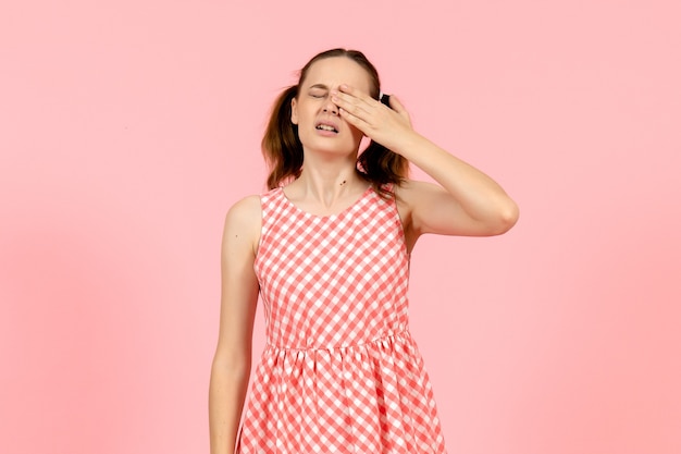 young girl in cute pink dress crying on pink