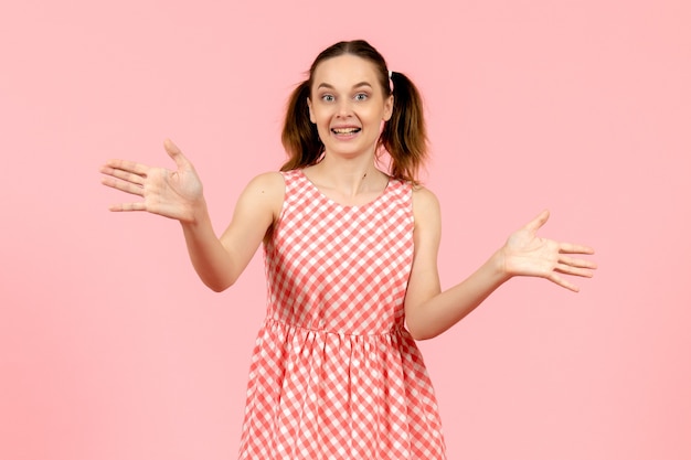 Free photo young girl in cute pink dress on light pink