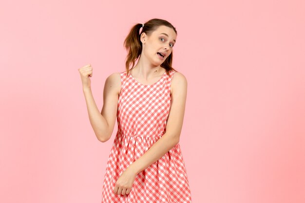 young girl in cute pink dress pointing on pink