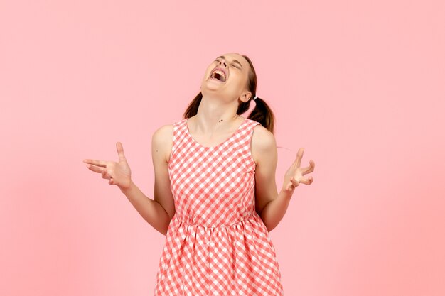 young girl in cute pink dress with angry expression on pink