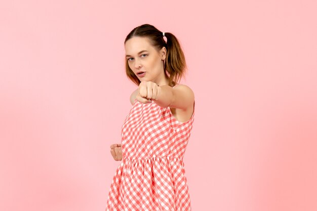 young girl in cute pink dress with concentrated expression on pink