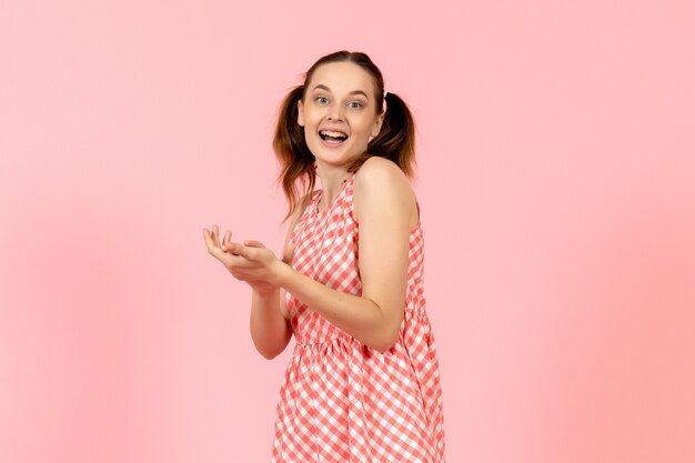 young girl in cute pink dress with delighted expression on pink