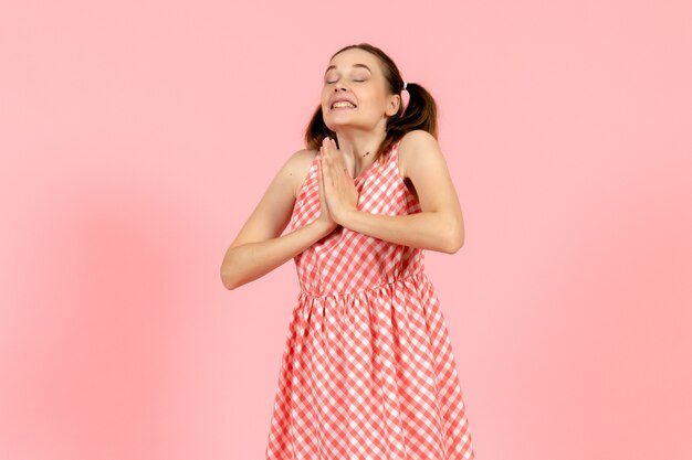 ピンクの興奮した表情でかわいいピンクのドレスの少女