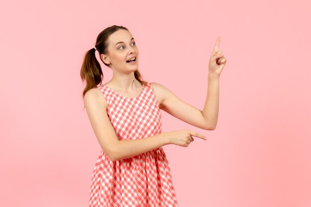 young girl in cute pink dress with excited expression on pink