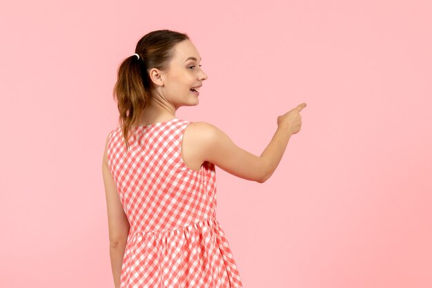 young girl in cute pink dress with excited expressionnd turned back on pink