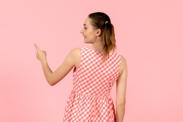 young girl in cute pink dress with excited expressionnd turned back on pink