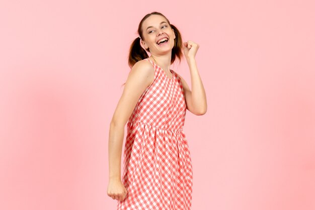 young girl in cute pink dress with happy expression on pink