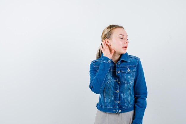 Young girl doing a hard of hearing gesture on white background
