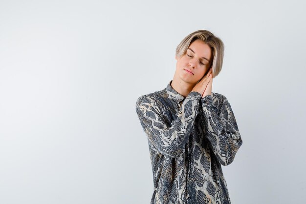 Young girl doing a sleep hand gesture on white background