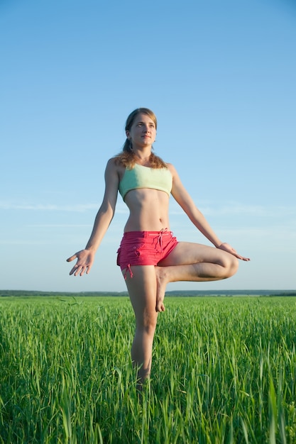 Young girl doing yoga against nature