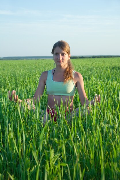 Young girl doing yoga against nature