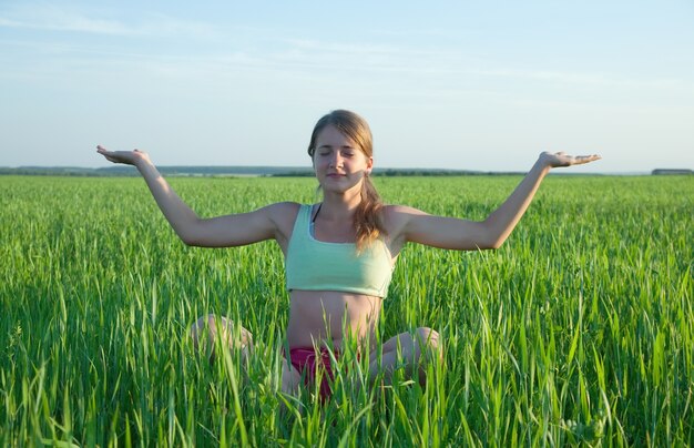 Young girl doing yoga against nature