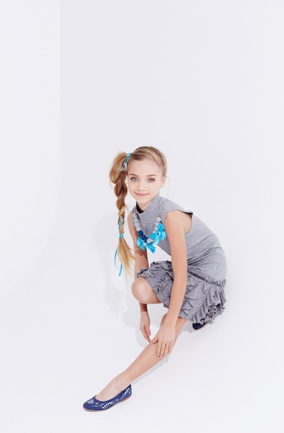 Young girl in a dress posing on white background