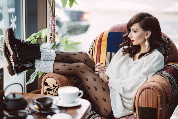 Free photo young girl drinking coffee in a trendy cafe